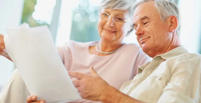 elderly couple smiling at a paper. alert1 medical alert system elderly couple smiling at a paper. alert1 medical alert system